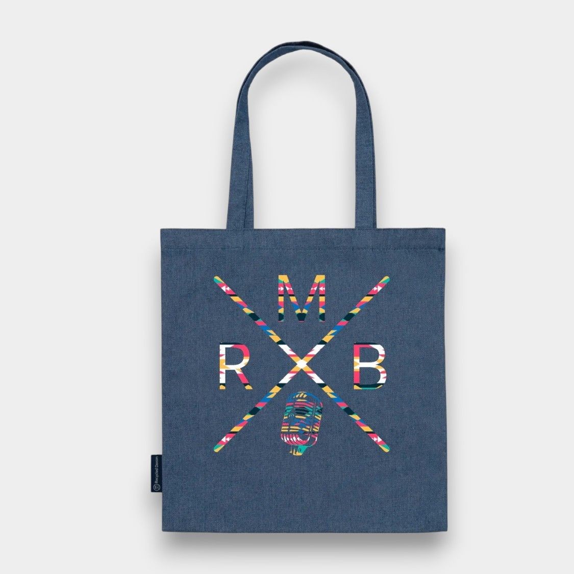 Blue tote bag with colorful geometric design and letters M, R, B on the front.